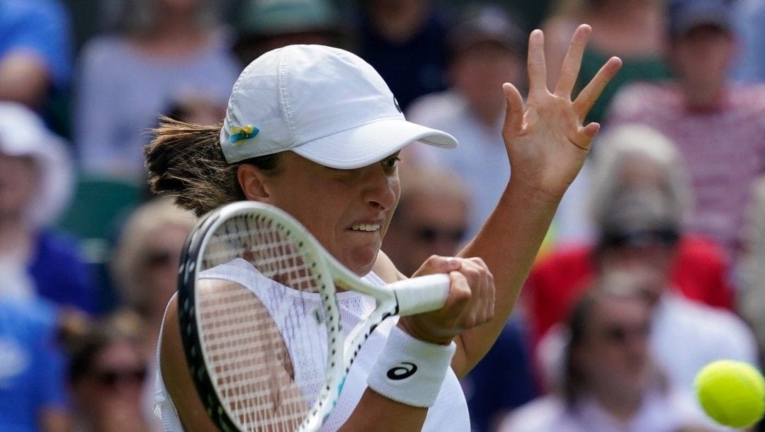 Poland's Iga Swiatek returns to Croatia's Jana Fett in a first round women's singles match on day two of the Wimbledon tennis championships in London, Tuesday, June 28, 2022.