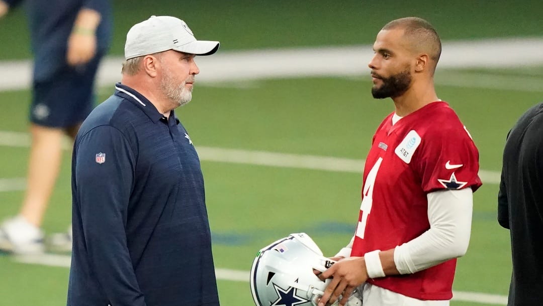 Dallas Cowboys head coach Mike McCarthy, left, speaks to quarterback Dak Prescott (4) during an NFL football team practice in Frisco, Texas, Thursday, June 2, 2022.