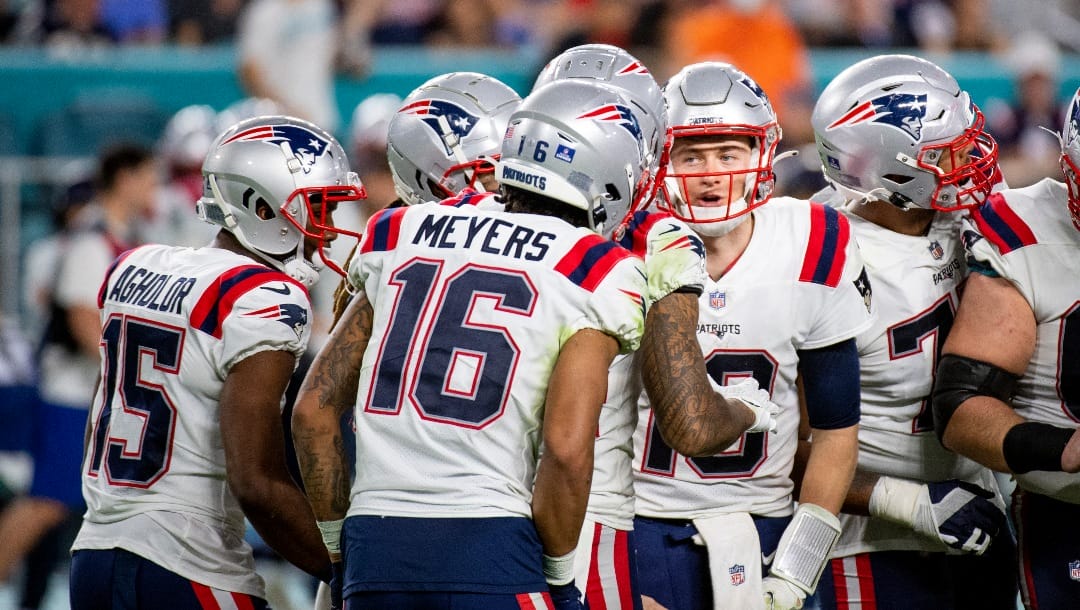 New England Patriots quarterback Mac Jones (10) calls a play in the huddle with New England Patriots wide receiver Nelson Agholor (15) and New England Patriots wide receiver Jakobi Meyers (16) during an NFL football game against the Miami Dolphins, Sunday, Jan. 9, 2022, in Miami Gardens, Fla.