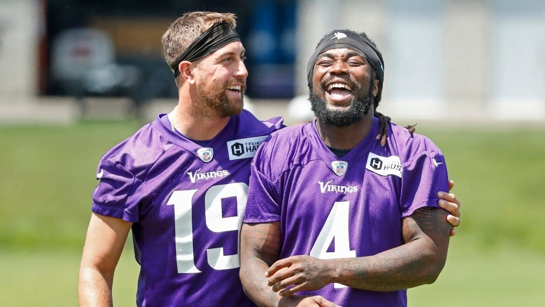 Minnesota Vikings wide receiver Adam Thielen (19) shares a laugh with running back Dalvin Cook (4) as they take part in drills at the NFL football team's practice facility in Eagan, Minn., Wednesday, June 8, 2022. (AP Photo/Bruce Kluckhohn)