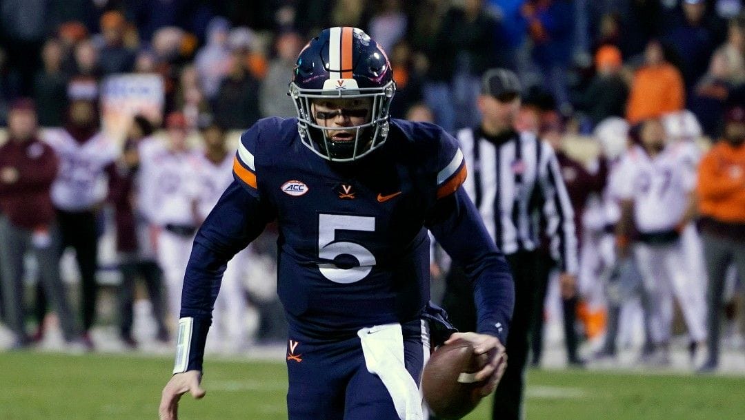 Virginia quarterback Brennan Armstrong (5) heads to the end zone for a score during the first half of an NCAA college football game Saturday Nov 27, 2021, in Charlottesville, Va.