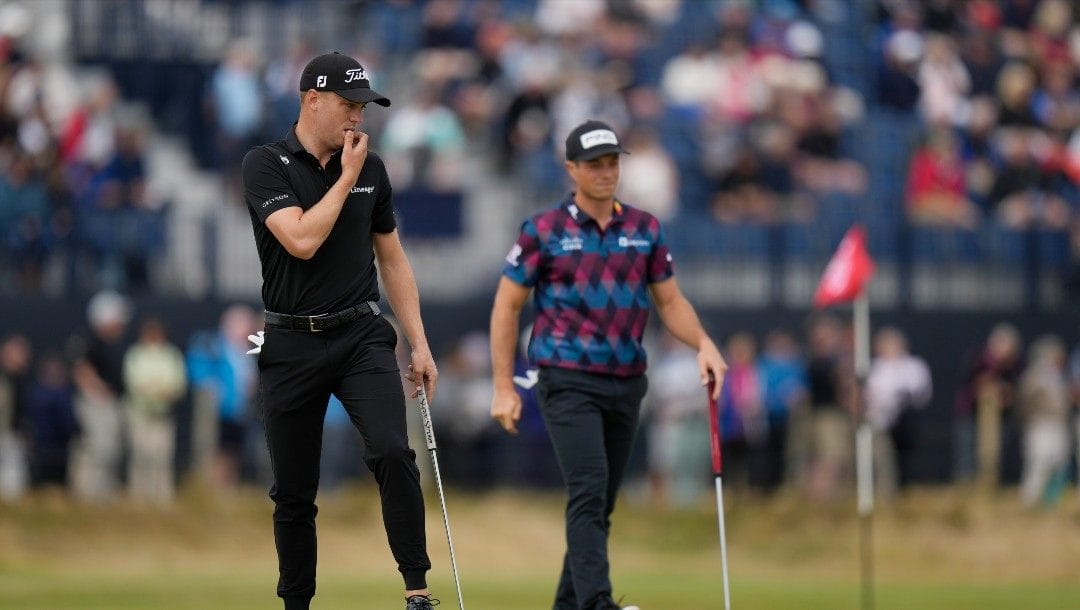Justin Thomas of the US, left, and Viktor Hovland, of Norway, on the 3rd green during the first round of the British Open golf championship on the Old Course at St. Andrews, Scotland, Thursday, July 14 2022.