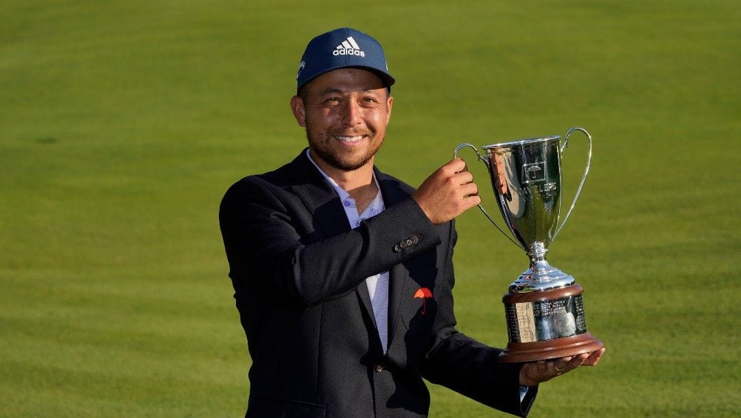 Xander Schauffele poses for pictures after winning the Travelers Championship golf tournament at TPC River Highlands, Sunday, June 26, 2022, in Cromwell, Conn.