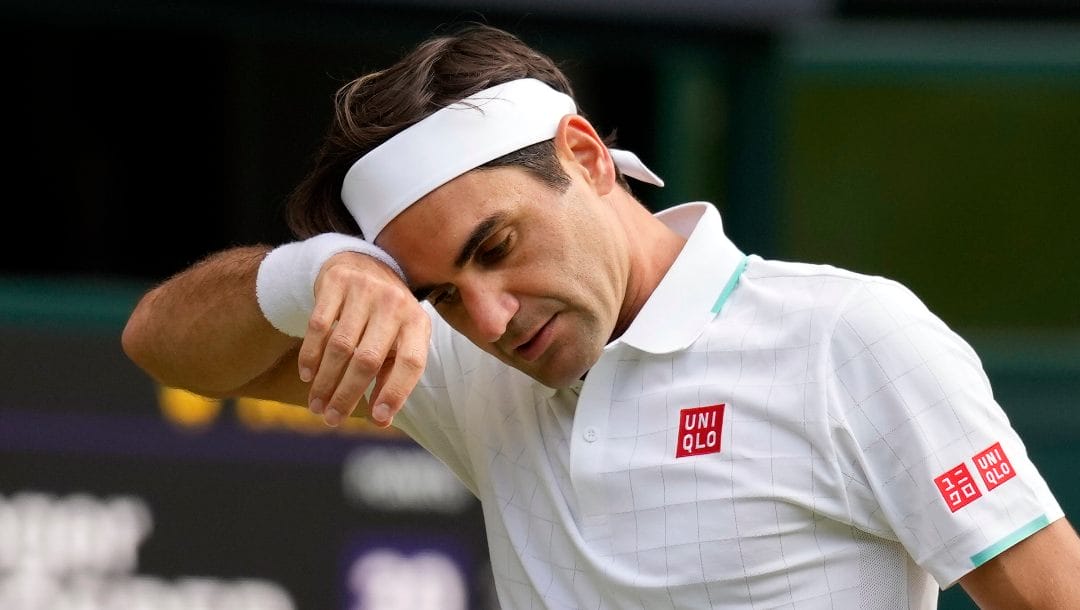 Switzerland's Roger Federer wipes his brow during the men's singles quarterfinals match against Poland's Hubert Hurkacz on day nine of the Wimbledon Tennis Championships in London.