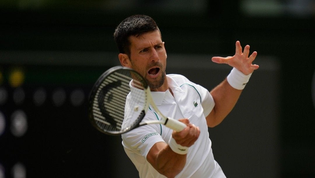 Serbia's Novak Djokovic returns to Italy's Jannik Sinner in a men's singles quarterfinal match on day nine of the Wimbledon tennis championships in London, Tuesday, July 5, 2022.
