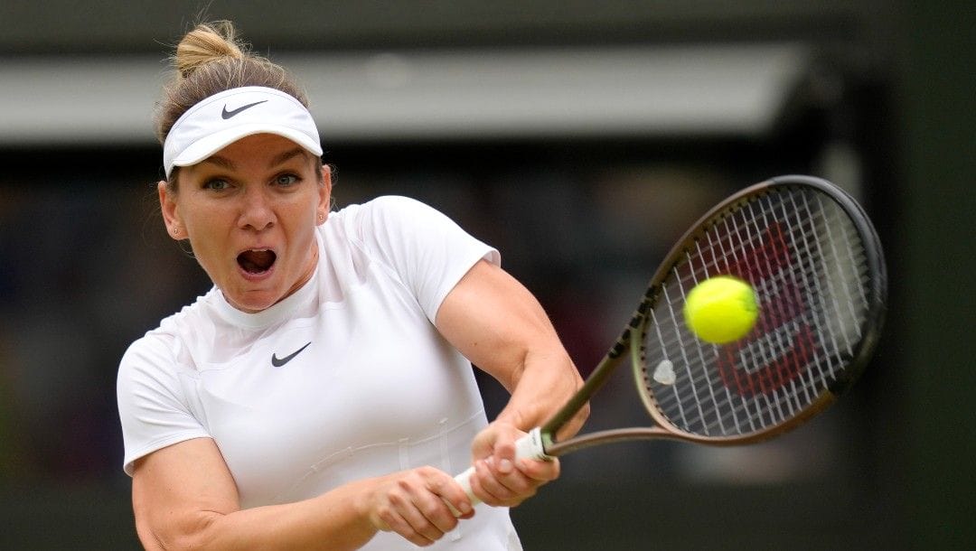 Romania's Simona Halep returns to Amanda Anisimova of the US in a women's singles quarterfinal match on day ten of the Wimbledon tennis championships in London, Wednesday, July 6, 2022.