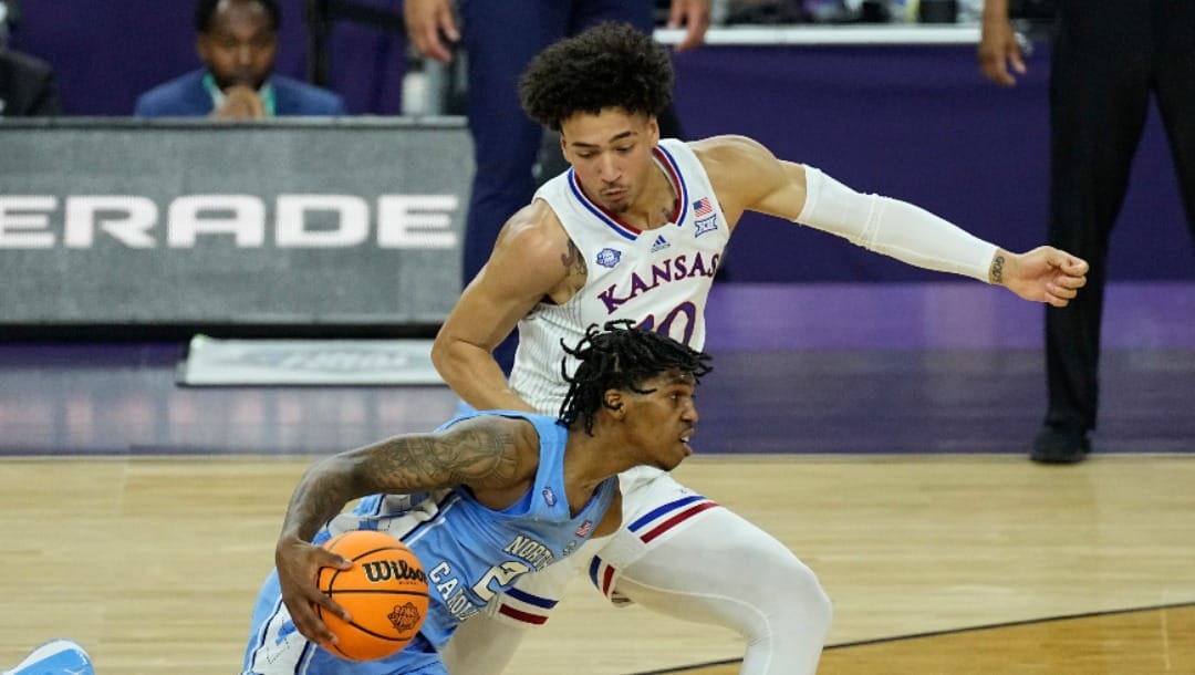 North Carolina guard Caleb Love, left, moves past Kansas forward Jalen Wilson during the second half of a college basketball game in the finals of the Men's Final Four NCAA tournament, Monday, April 4, 2022, in New Orleans. (AP Photo/Gerald Herbert)