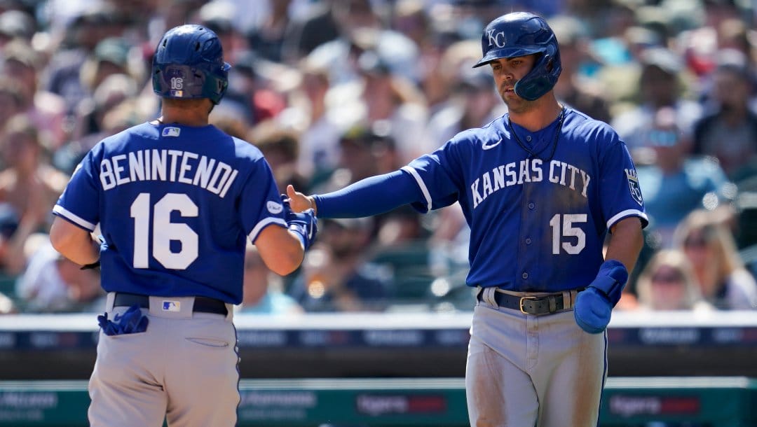 Kansas City Royals' Andrew Benintendi (16) and Whit Merrifield (15) celebrate scoring against the Detroit Tigers in the first inning of a baseball game in Detroit, Saturday, July 2, 2022.