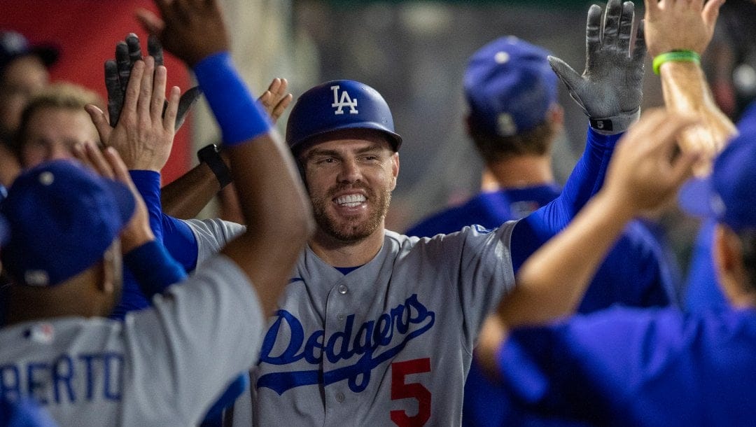 Los Angeles Dodgers' Freddie Freeman celebrates in the dugout after hitting a solo home run against the Los Angeles Angels during the fifth inning of a baseball game in Anaheim, Calif., Saturday, July 16, 2022.