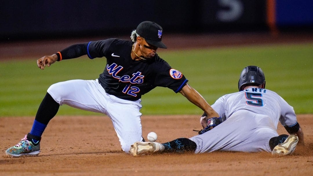 Miami Marlins' Jon Berti (5) slides past New York Mets' Francisco Lindor (12) to steal second base during the sixth inning of a baseball game Friday, June 17, 2022, in New York.