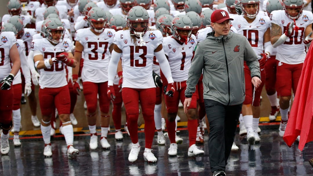 Washington State coach Jake Dickert leads his team onto the field to face Central Michigan in the Sun Bowl NCAA college football game in El Paso, Texas, Friday, Dec. 31, 2021.