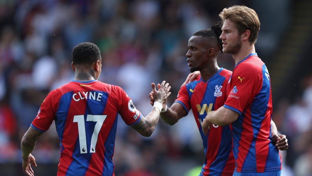 Crystal Palace's Wilfried Zaha, center, celebrates with teammates after scoring his side's first goal during the English Premier League soccer match between Manchester United and Crystal Palace at Selhurst Park stadium in London, Sunday, May 22, 2022.