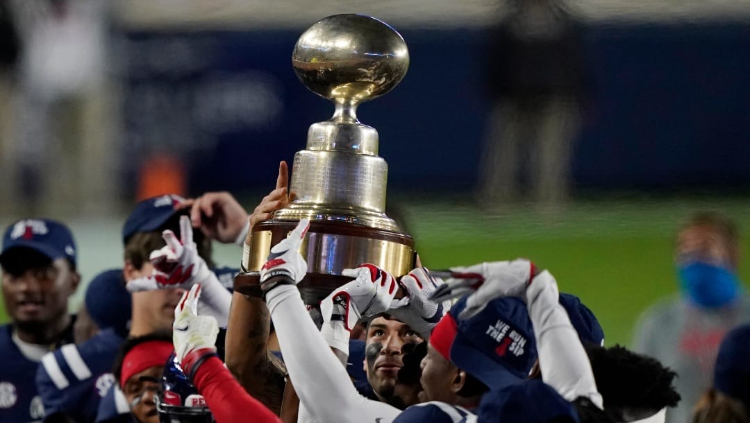 Mississippi quarterback Matt Corral looks up at the "Egg Bowl" trophy beating in state rival Mississippi State, 31-24, at an NCAA college football game, Saturday, Nov. 28, 2020, in Oxford, Miss. (AP Photo/Rogelio V. Solis)