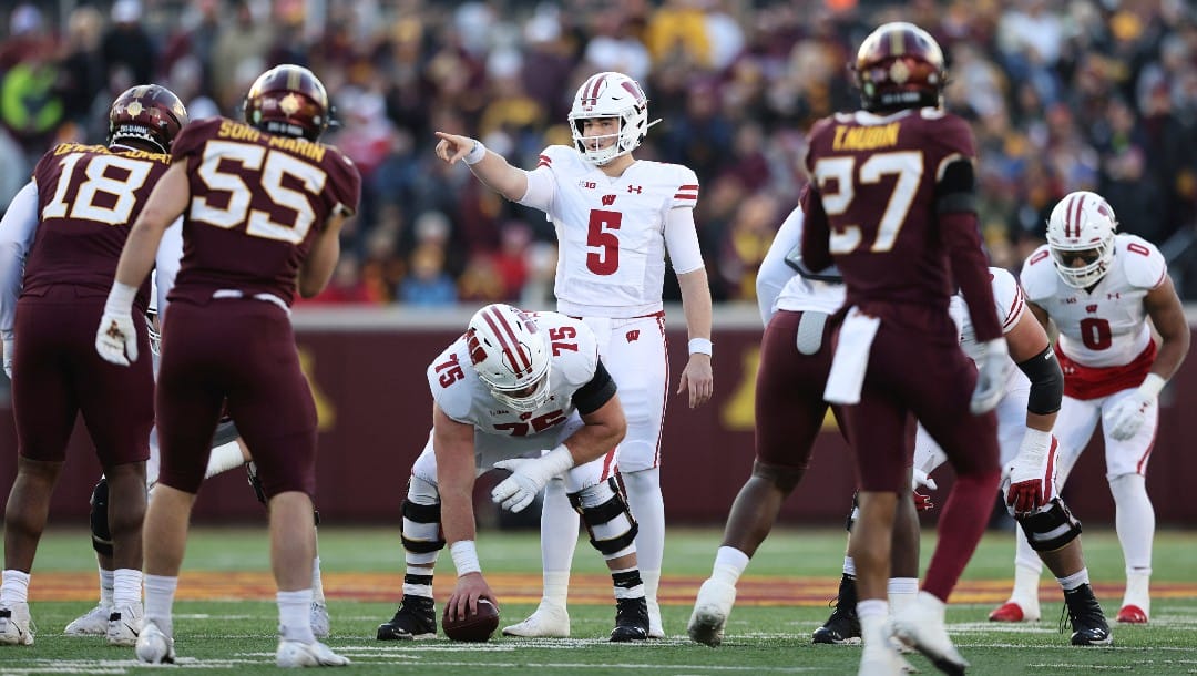 Wisconsin quarterback Graham Mertz (5) calls out a play before the snap during the first half of an NCAA college football game against Minnesota, Saturday, Nov. 27, 2021, in Minneapolis. (AP Photo/Stacy Bengs)