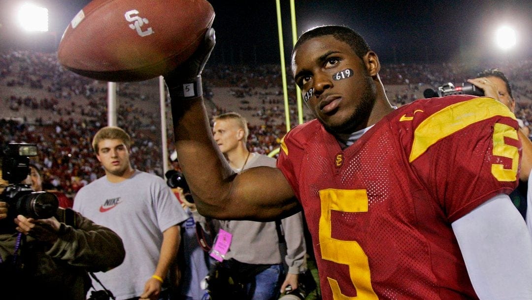 Southern California tail back Reggie Bush walks off the field holding the game ball after the Trojans defeated Fresno State, 50-42, at the Los Angeles Coliseum.