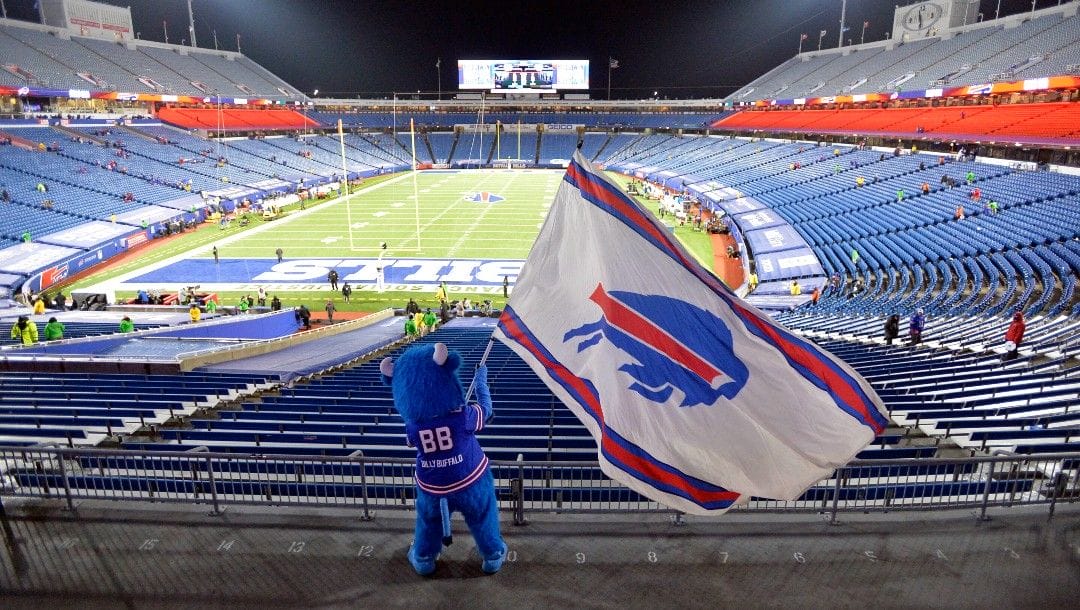 Buffalo Bills fans leave Bills Stadium as a mascot waves a flag after an NFL divisional round football game against the Baltimore Ravens, Jan. 16, 2021, in Orchard Park, N.Y. State
