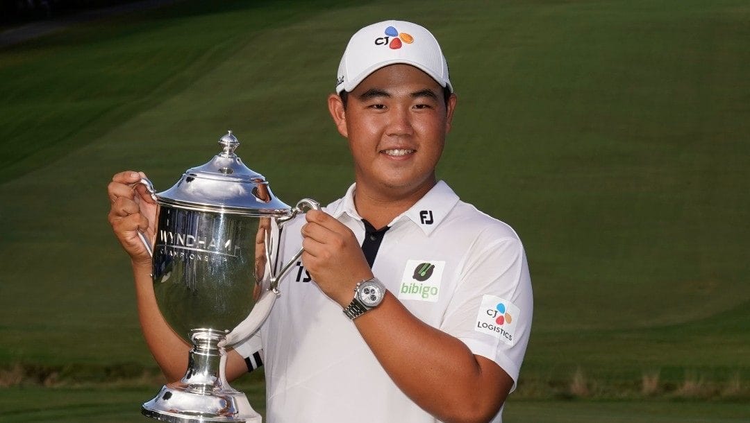 Joohyoung Kim, right, of South Korea, poses with the trophy after winning the Wyndham Championship golf tournament in Greensboro, N.C., Sunday, Aug. 7, 2022.