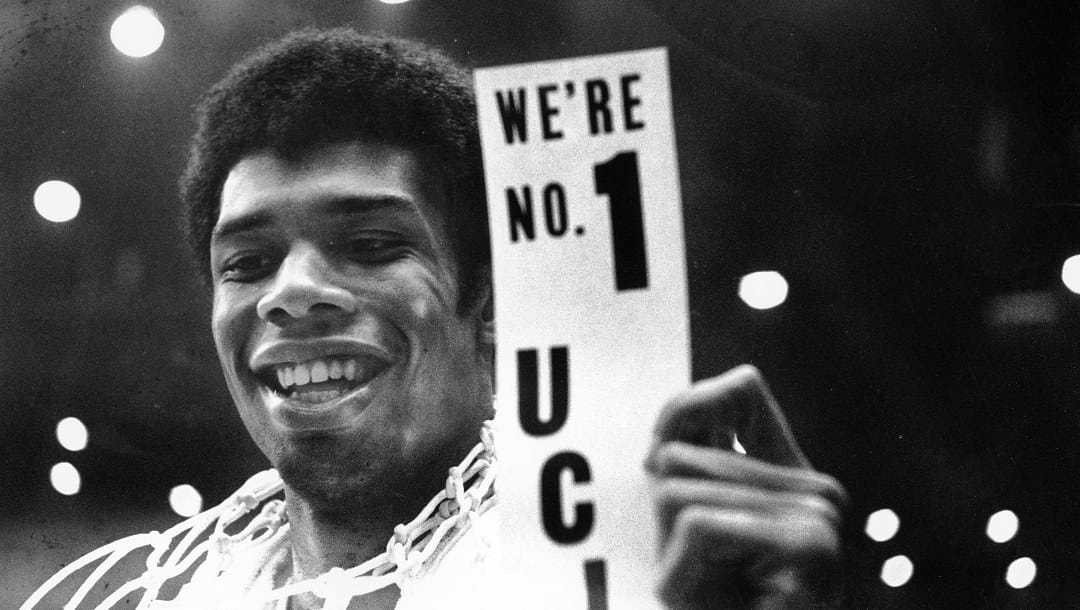 FILE - In this March 23, 1968, file photo, UCLA's Lew Alcindor, with the basket netting draped over his shoulders, holds a sign just after leading UCLA to the NCAA basketball championship in Los Angeles on March 23, 1968. Muhammad Ali’s actions influenced others. Alcindor boycotted the 1968 Summer Olympics. boycotted the 1968 Summer Olympics. After winning his first NBA championship in 1971, he took the Muslim name Kareem Abdul-Jabbar. (AP Photo/File)
