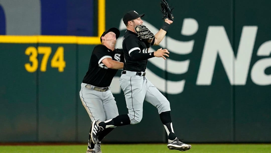 Chicago White Sox right fielder Andrew Vaughn, left, and center fielder AJ Pollock, right, collide as Vaughn holds on to an RBI sacrifice fly by Texas Rangers' Marcus Semien during the seventh inning of a baseball game Thursday, Aug. 4, 2022, in Arlington, Texas.