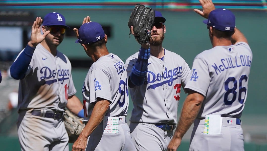 Los Angeles Dodgers' Joey Gallo, left, third base coach Dino Ebel, Cody Bellinger and first base coach Clayton McCullough (86) celebrate after the Dodgers defeated the San Francisco Giants in a baseball game in San Francisco, Thursday, Aug. 4, 2022.