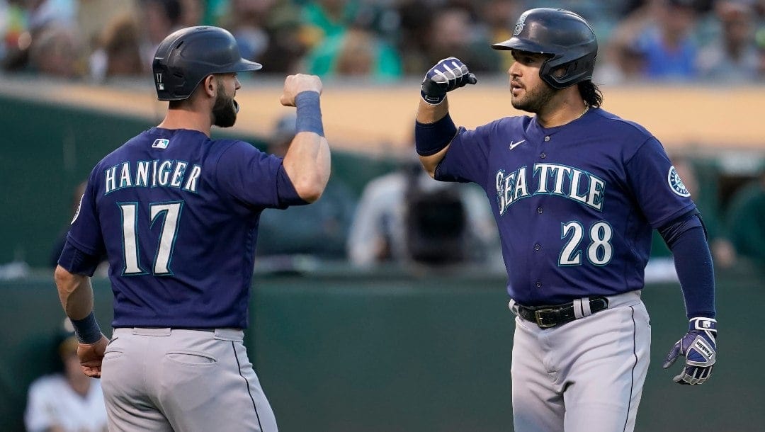 Seattle Mariners' Eugenio Suarez (28) celebrates after hitting a two-run home run that scored Mitch Haniger (17) during the fourth inning of a baseball game against the Oakland Athletics in Oakland, Calif., Friday, Aug. 19, 2022.