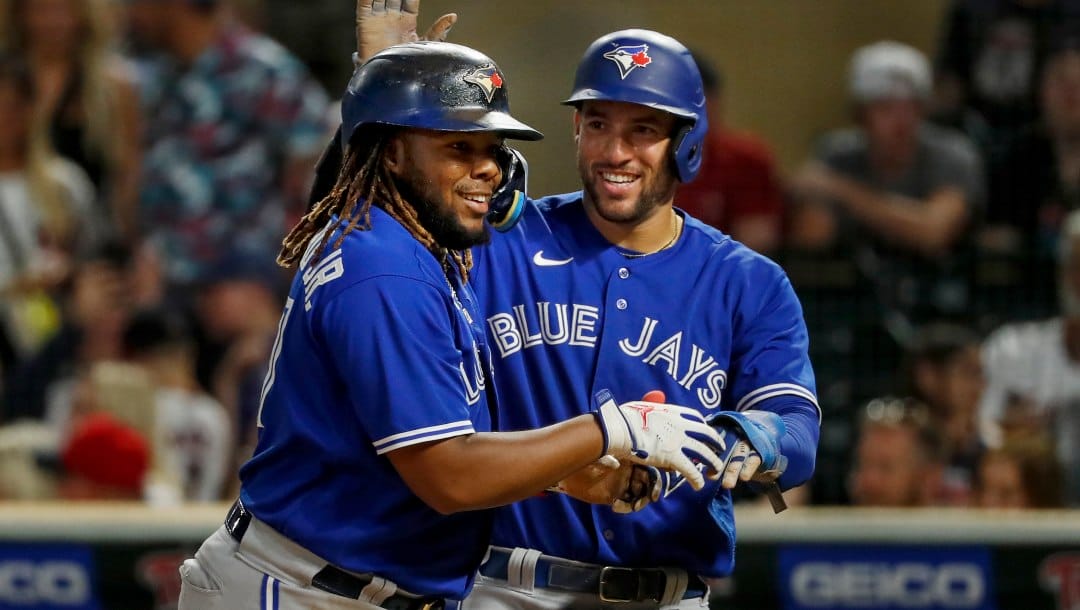 Toronto Blue Jays' Vladimir Guerrero, left, celebrates his three-run home run against the Minnesota Twins with George Springer during the eighth inning of a baseball game Thursday, Aug. 4, 2022, in Minneapolis.