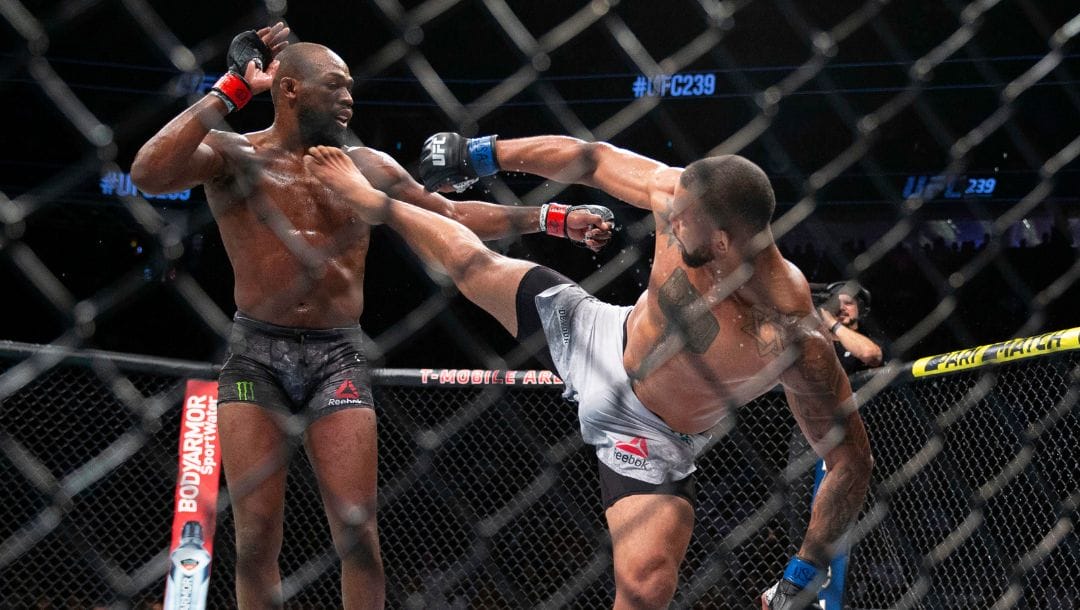Jon Jones, left, avoids a kick from Thiago Santos during the second round of their light heavyweight mixed martial arts title bout
