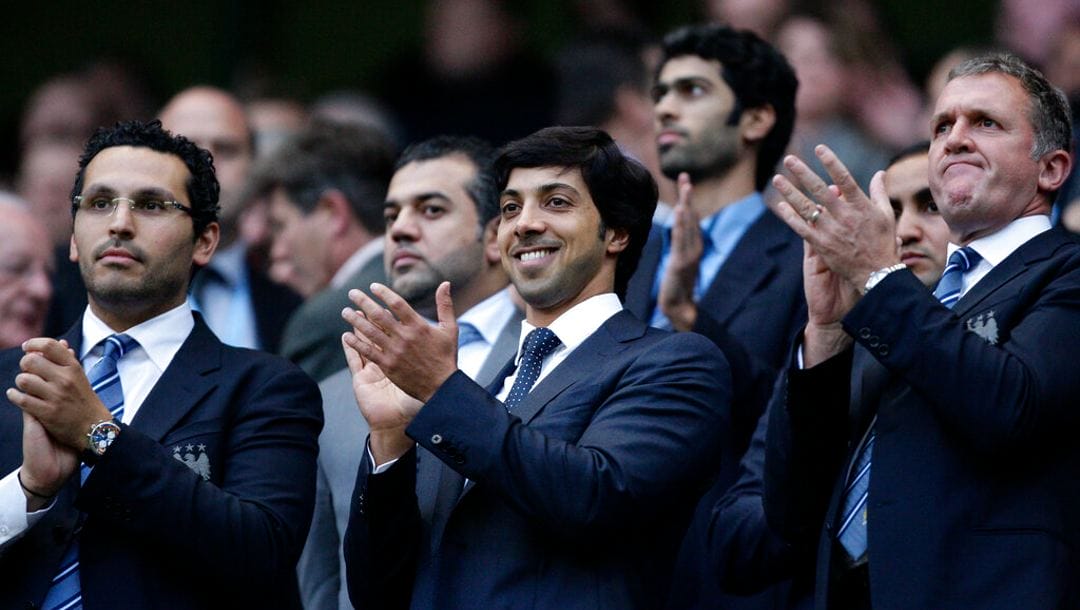 Manchester City's owner Sheikh Mansour, centre, applauds as he stands between chief executive Garry Cook, right, and chairman Khaldoon Al Mubarak.