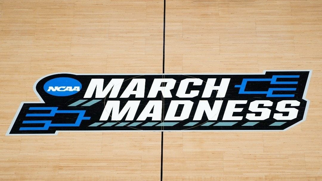 The March Madness logo is shown on the court during the first half of a men's college basketball game in the first round of the NCAA tournament at Bankers Life Fieldhouse in Indianapolis, Saturday, March 20, 2021.