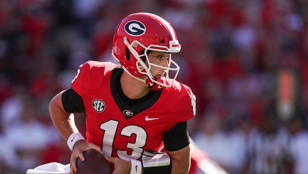 Georgia quarterback Stetson Bennett (13) rolls out to pass against Kentucky during the first half of an NCAA college football game Saturday, Oct. 16, 2021 in Athens, Ga.
