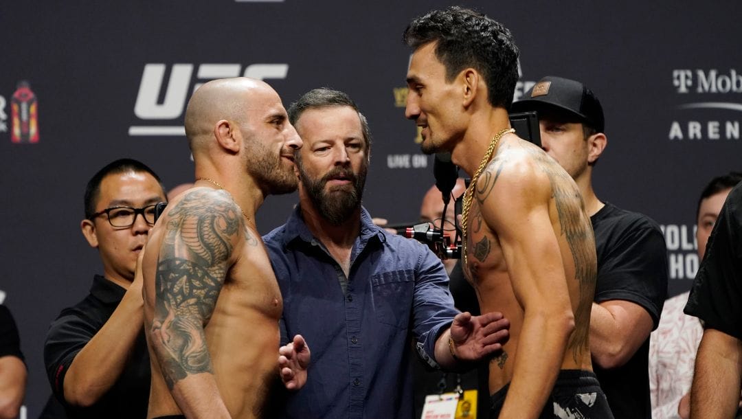 Alexander Volkanovski, left, and Max Holloway face off during a ceremonial weigh-in for the UFC 276 mixed martial arts event.