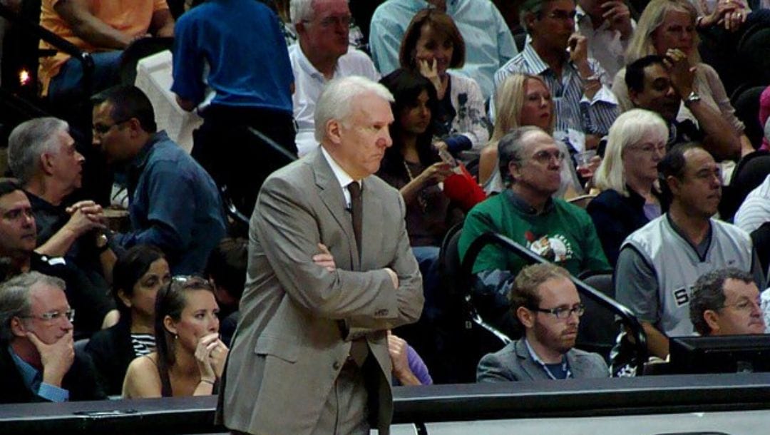 Gregg Popovich observing the San Antonio Spurs game from the sidelines.