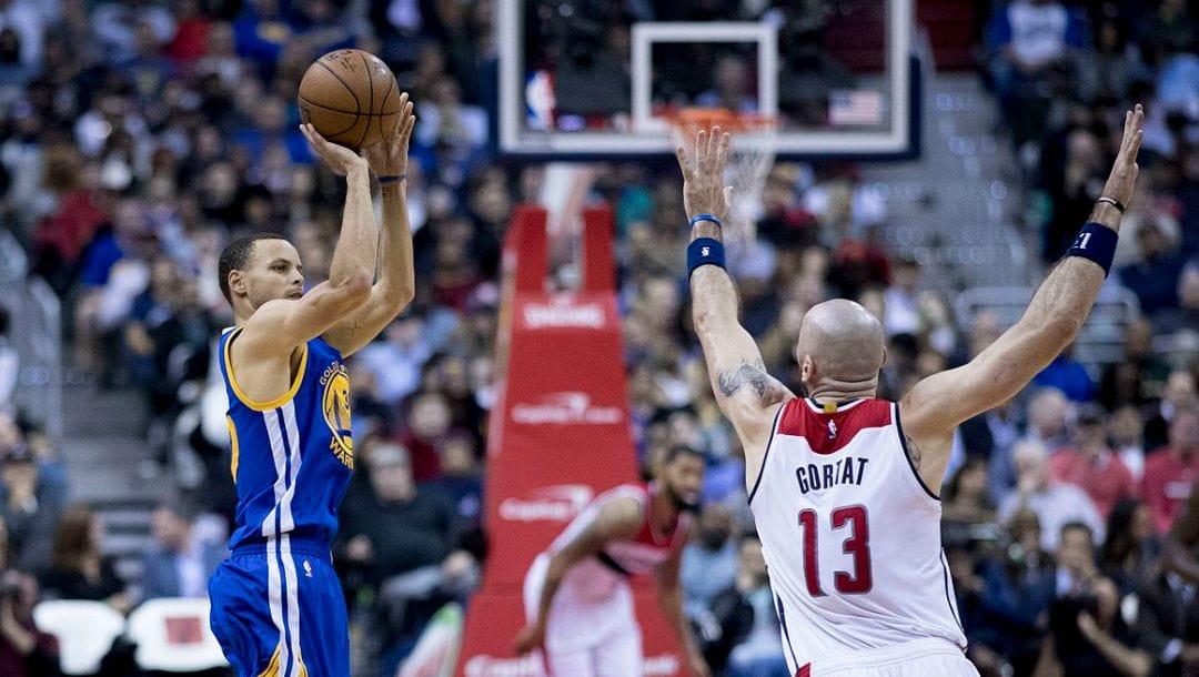 Stephen Curry of the Golden State Warriors shoots over Marcin Gortat of the Washington Wizards.