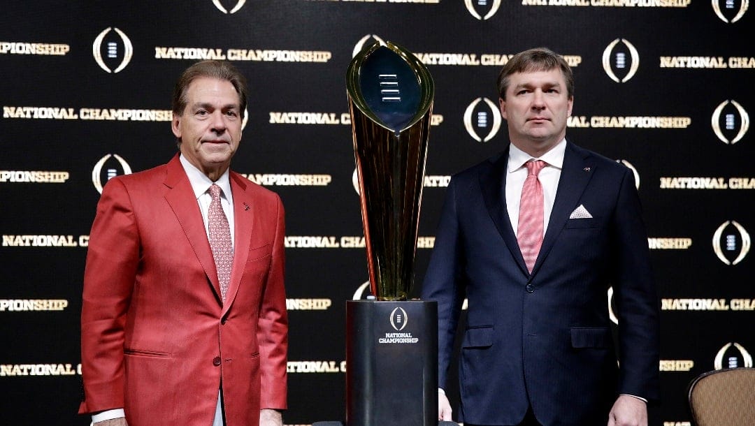 Alabama head coach Nick Saban, left, and Georgia head coach Kirby Smart pose with the NCAA college football championship trophy at a press conference in Atlanta, Sunday, Jan. 7, 2018. Georgia and Alabama will be playing for the championship on Monday, Jan. 8. (AP Photo/David Goldman)