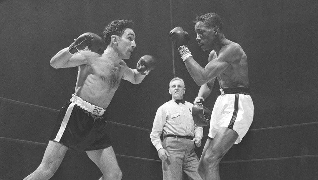 Willie Pep, left, unleashes a two fisted attack against feather weight champion Sandy Saddler in the fourth round.