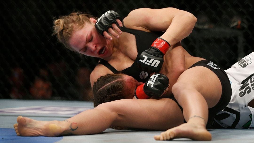 Ronda Rousey, top, grapples with Liz Carmouche during their UFC 157 women's bantamweight championship mixed martial arts match.