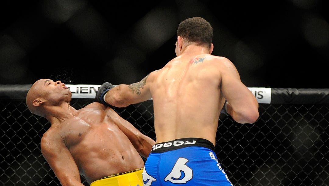 Chris Weidman connects with Anderson Silva during the second round during their UFC 162 mixed martial arts.