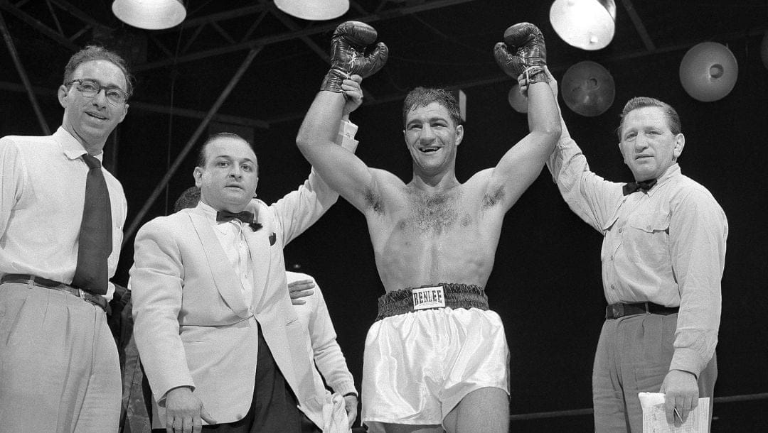 Rocky Marciano, of Brockton, Mass., gets victory gesture with help of Referee Ray Miller, right, and John Addie (second from left).