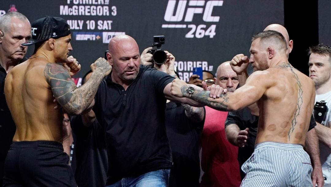 Dana White, UFC President, stands between Conor McGregor, right, and Dustin Poirier during a ceremonial weigh-in for a UFC 264.