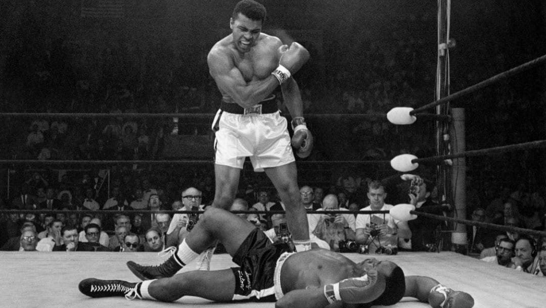 Heavyweight champion Muhammad Ali stands over fallen challenger Sonny Liston, shouting and gesturing shortly after dropping Liston.
