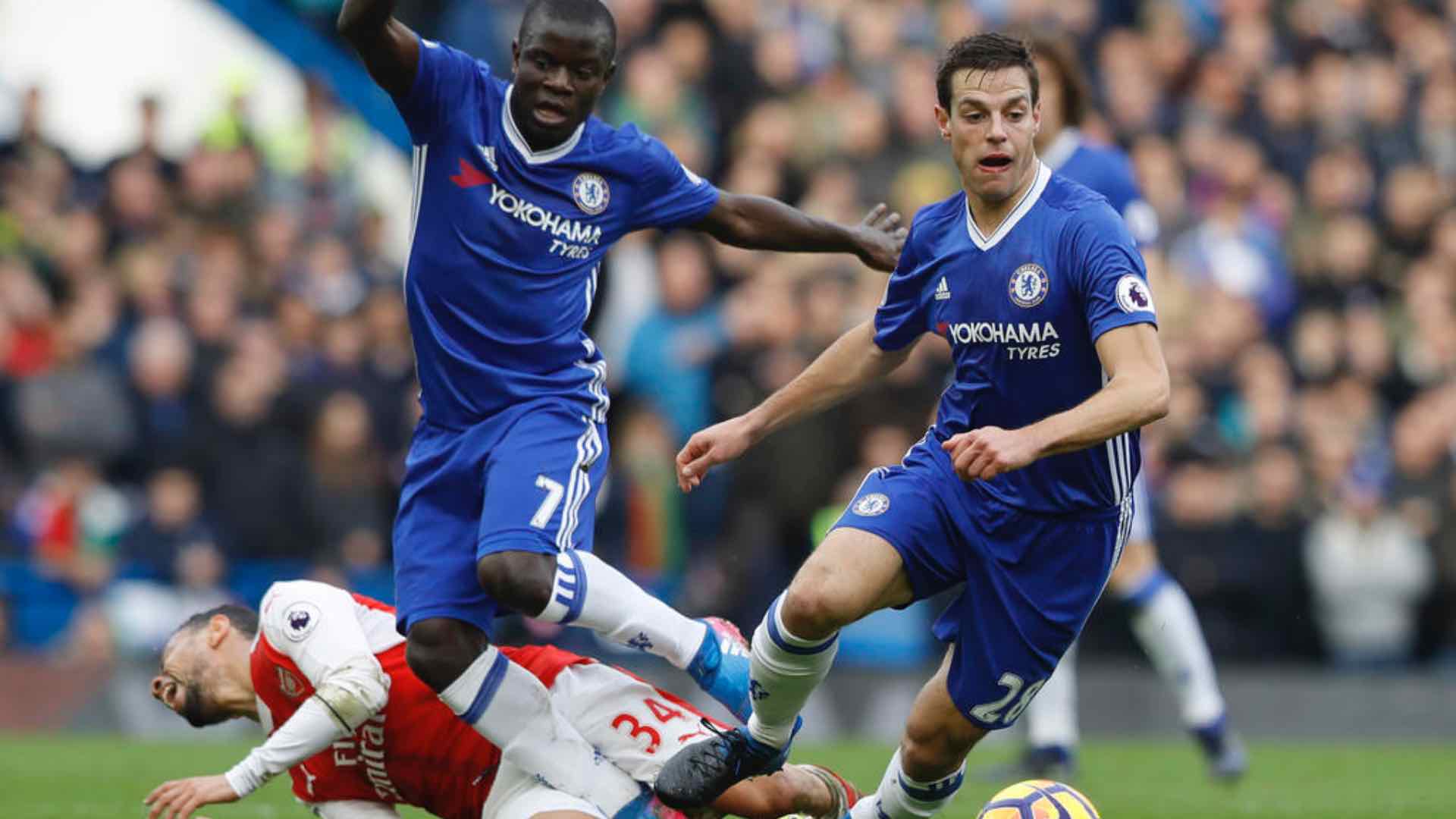 Chelsea's Cesar Azpilicueta, right, takes the ball forward as Arsenal's Francis Coquelin falls to the ground.
