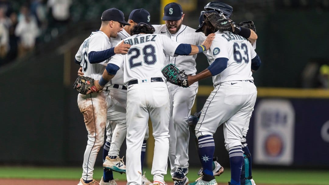 Seattle Mariners, including, from left, Adam Frazier, Eugenio Suarez, Curt Casali, and Diego Castillo, celebrate a 9-6 win in the second game of a baseball doubleheader against the Detroit Tigers, Tuesday, Oct. 4, 2022, in Seattle.