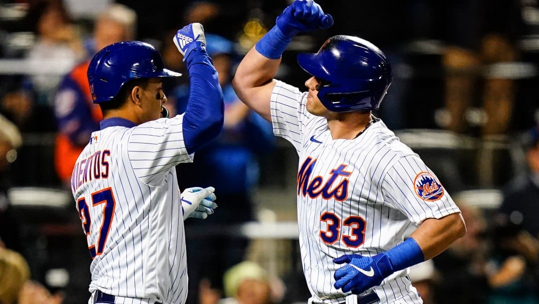 New York Mets' Mark Vientos celebrates with James McCann (33) after they scored on a three-run home run by McCann during the third inning of a baseball game against the Washington Nationals, Wednesday, Oct. 5, 2022, in New York.