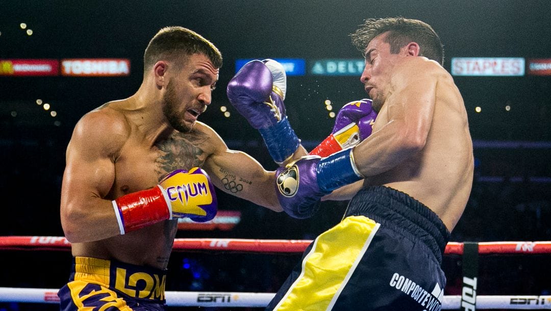 Vasiliy Lomachenko, left, from Ukraine, hits Anthony Crolla, from Britain, during a WBA and WBO lightweight title boxing bout.