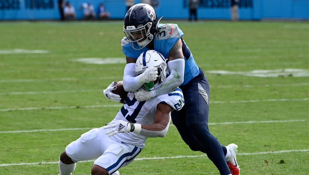 Indianapolis Colts running back Nyheim Hines (21) is stopped by Tennessee Titans safety Amani Hooker during the second half of an NFL football game Sunday, Oct. 23, 2022, in Nashville, Tenn. (AP Photo/Mark Zaleski)