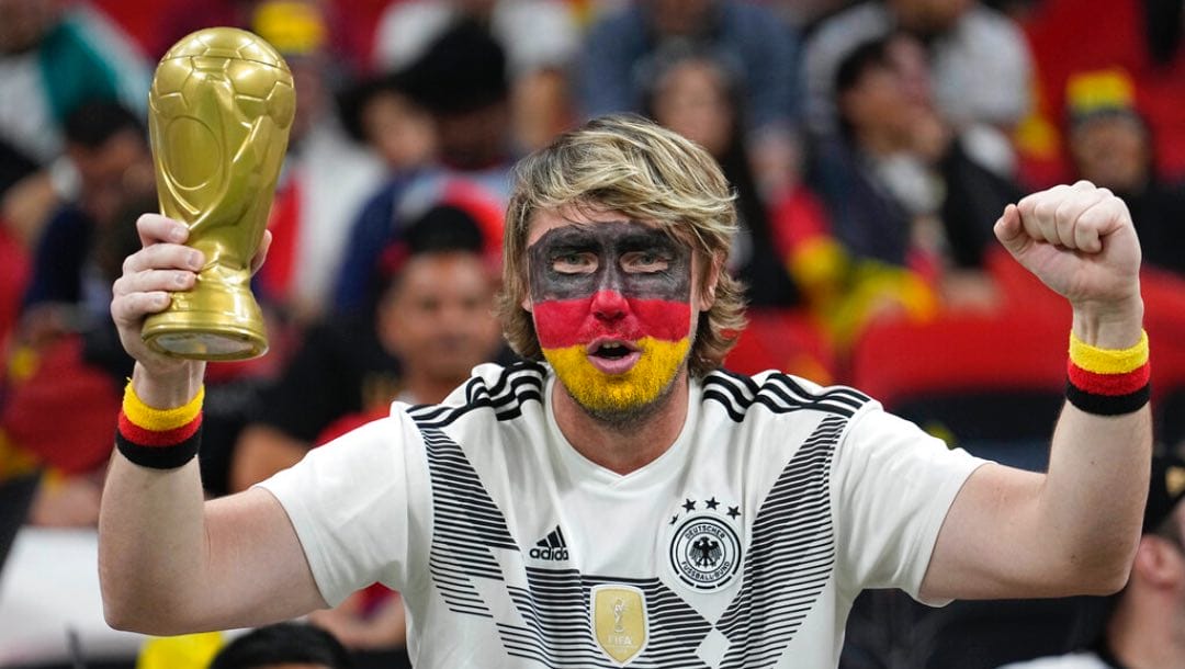 A German soccer fan holds a replica of the Cup and waits for the start of the World Cup group E soccer match between Spain and Germany, at the Al Bayt Stadium in Al Khor, Qatar, Sunday, Nov. 27, 2022.