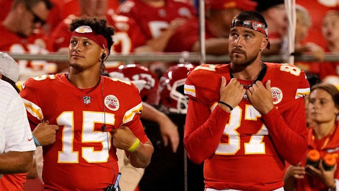 Kansas City Chiefs quarterback Patrick Mahomes (15) and tight end Travis Kelce (87) watch from the sidelines during the second half of an NFL preseason football game against the Green Bay Packers Thursday, Aug. 25, 2022, in Kansas City, Mo.