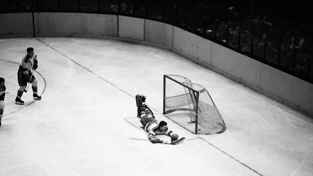 New York Rangers goalie Lorne Worsley lies flat on the ice as he peers into the net at puck after it was pushed in by Gus Bodnar for a Chicago Black Hawks’ score in final period of NHL game at Madison Square Garden in New York City, Nov. 12, 1952. Four other goals by Wally Hergesheimer enabled the Rangers to beat Black Hawks, 5-2. (AP Photo/John Lent)