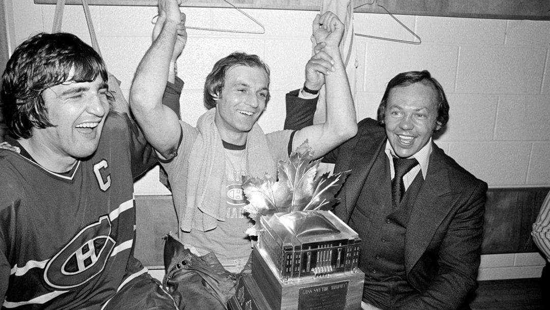 Montreal Canadiens' Guy Lafleur, center, team captain Serge Savard, left, and Yvan Cournoyer celebrate Lafleur's win of the Conn Smythe Most Valuable Player trophy in the team's dressing room after their Stanley Cup victory at Boston Garden in Boston, Ma., May 14, 1977.