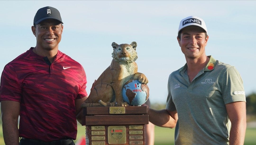 Viktor Hovland, of Norway, right, and Tiger Woods pose with the championship trophy after the final round the Hero World Challenge PGA Tour at the Albany Golf Club, in New Providence, Bahamas, Sunday, Dec. 5, 2021.
